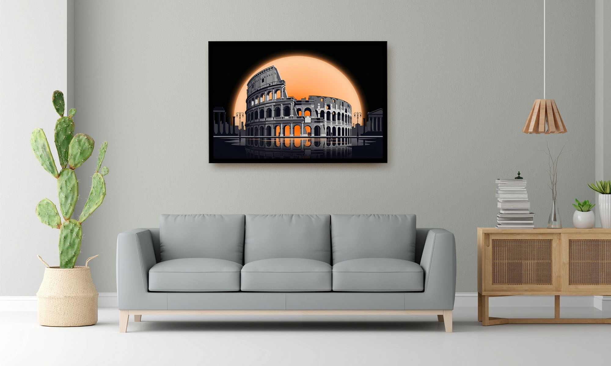 A framed wall art print depicting the Colosseum at night with a large glowing orange moon, shown hanging above a light gray sofa in a modern living room setting.