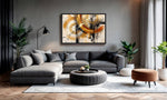 A modern living room featuring a large framed abstract canvas print with gold, black, and white brushstrokes on a gray wall above a gray sectional sofa.