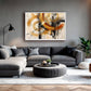 A modern living room featuring a large framed abstract canvas print with gold, black, and white brushstrokes on a gray wall above a gray sectional sofa.