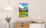 Framed artwork of a mountain landscape hanging on a wall above a wooden console table.