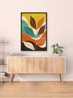Colorful abstract leaf art on a wall above a wooden cabinet.