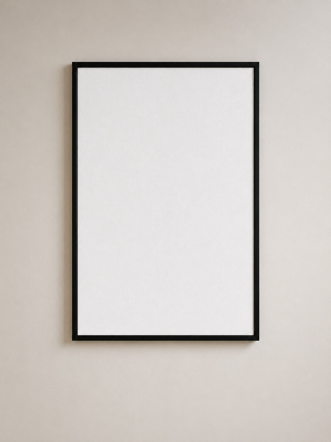 A minimalist black picture frame with a blank white mat, mounted on a neutral beige wall.