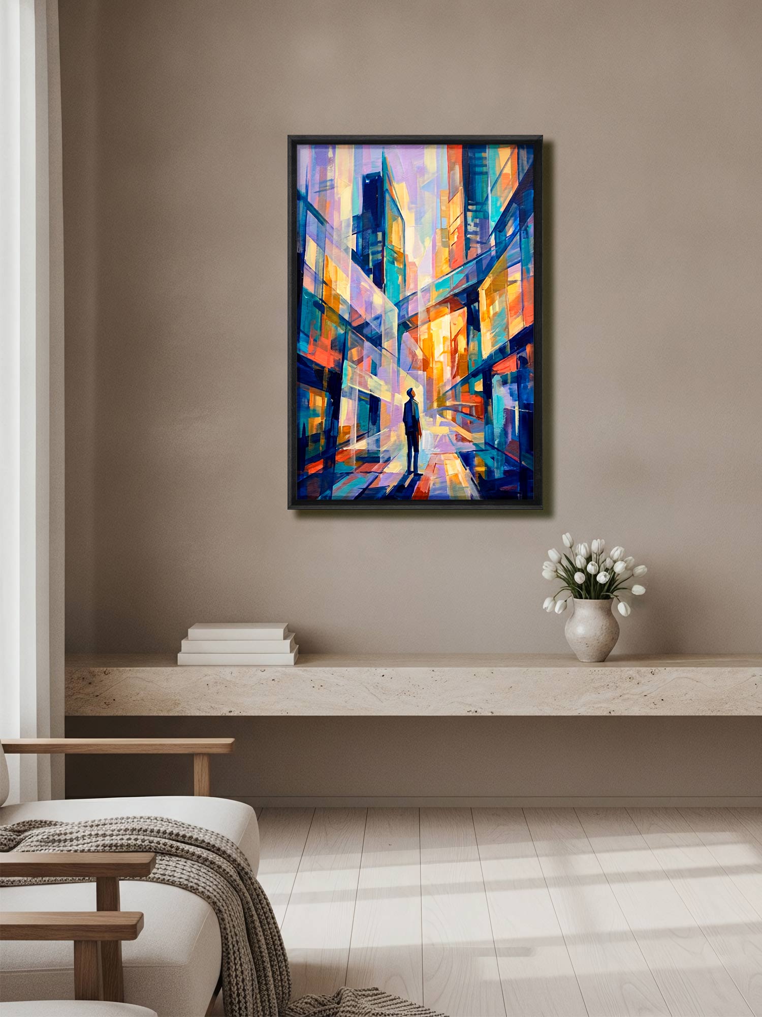 A framed abstract painting of a city street with colorful geometric buildings hangs on a beige wall in a modern living room setting.