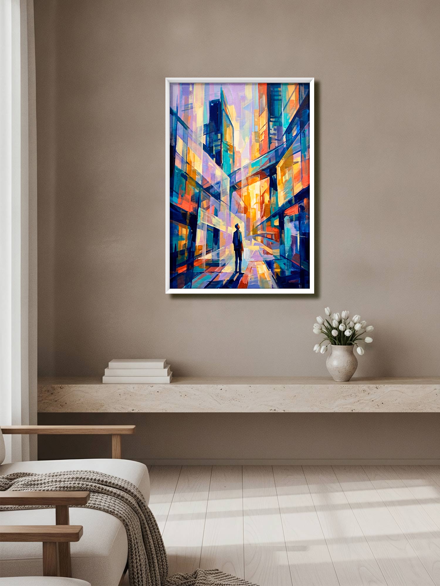 A framed abstract painting of a city street with colorful buildings and a silhouetted figure, displayed on a beige wall above a light wood console in a modern living room setting.