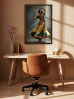 A framed painting of a dancing woman in a flowing multicolored dress hangs on a beige wall above a light wood desk with a brown leather chair. The room has warm sunlight and shadows, with a vase of pink flowers on the left.