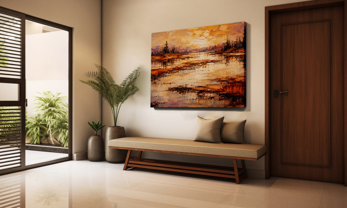 An abstract landscape canvas print with warm orange, brown, and gold tones, displayed on a beige wall above a wooden bench in a modern, sunlit entryway.
