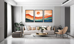 Modern living room with a gray sofa, coffee table, and wall art depicting a sunset.