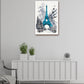 A vertical framed wall art print featuring a blue and white watercolor-style Eiffel Tower scene, displayed above a white sideboard in a modern room with two potted plants and a small clock.