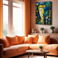 A colorful abstract canvas print of a face in blue, green, and gold tones, displayed on a beige wall in a modern living room with orange sectional sofas and a wooden coffee table.