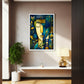A framed abstract art print featuring a stylized face in blue, green, and gold tones, displayed on a beige wall in a modern interior setting with a shelf, lamp, and plant.