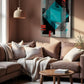 A modern living room featuring a large abstract geometric canvas print with teal, black, red, and gray shapes on a light gray background, hung on a warm brown wall above a beige sectional sofa.