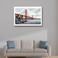 A framed art print of the Golden Gate Bridge hanging on a light gray wall above a beige sofa with blue accent pillows in a modern living room setting.