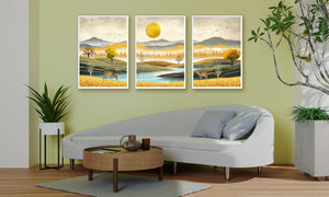Luxury triptych set of 3 canvas wall art featuring golden meadows, tranquil river, deer, mountain landscapes, forest silhouettes, and a radiant golden sun.