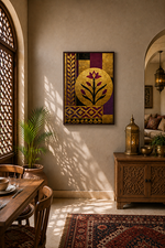 A framed golden canvas wall art print featuring a stylised floral motif in gold, purple, and red, displayed in a warm, sunlit dining room with wooden furniture and a patterned rug.
