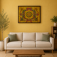A golden Mosaic wall art piece with a colourful geometric and floral central motif hangs on a mustard yellow wall above a cream sofa in a styled living room.