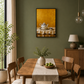 A framed art print depicting a teapot on a table against a golden-yellow background, hung on a dark olive green wall in a styled dining room with a wooden dining table, chairs, and a vase.
