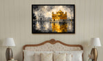 A framed art print depicting the Golden Temple in Amritsar, displayed on a beige paneled wall above a bed with pillows and bedside lamps.