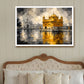 A framed painting of the Golden Temple in Amritsar, depicted in a bedroom setting above a wooden bed with patterned pillows and two bedside lamps.