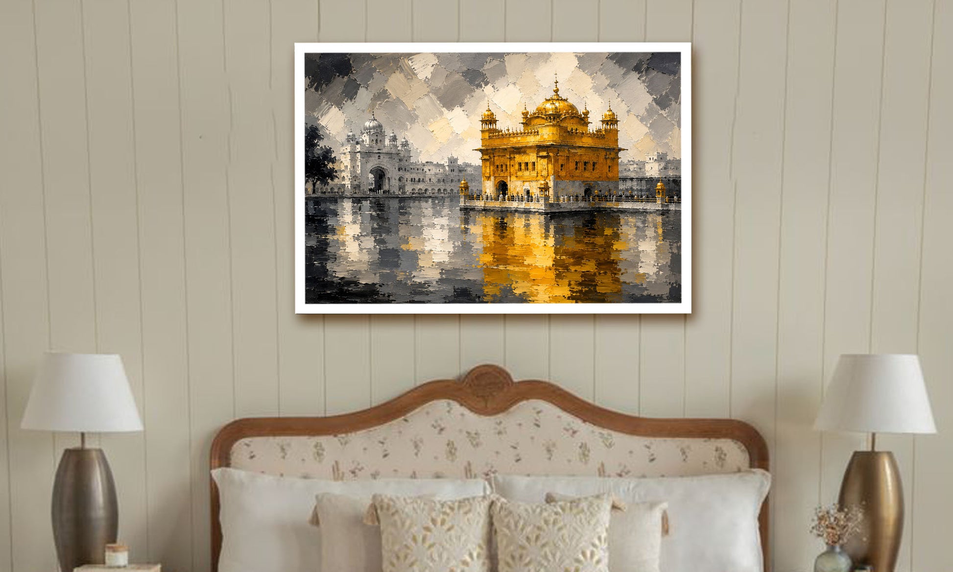 A framed painting of the Golden Temple in Amritsar, depicted in a bedroom setting above a wooden bed with patterned pillows and two bedside lamps.