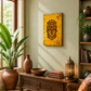 A bohemian-style living room featuring a yellow canvas print of a red and gold mask on the wall above a carved wooden console table. The room is decorated with potted plants, ceramic vases, books, and a patterned armchair.