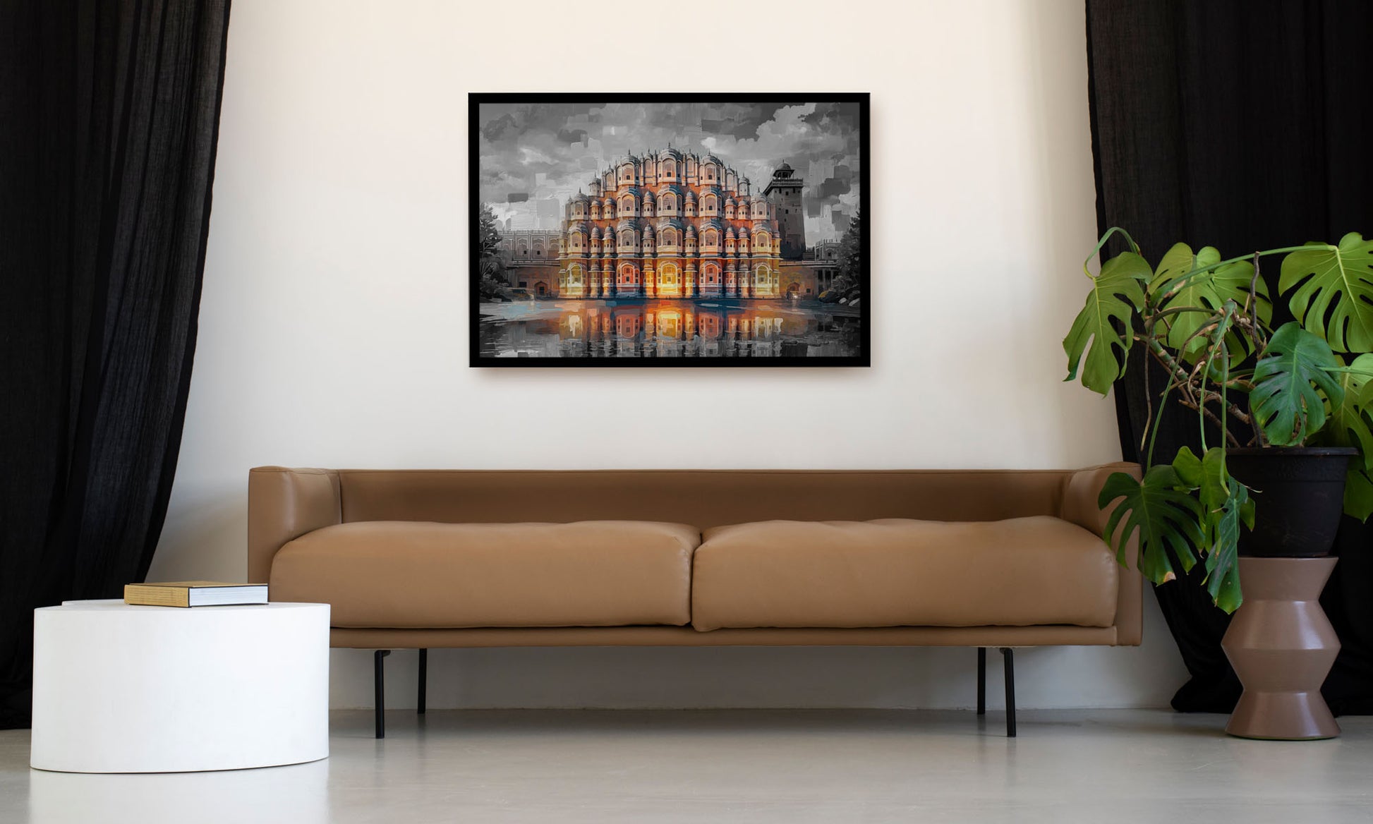 A framed art print depicting a grand classical amphitheater with warm orange and yellow light reflections, displayed on a white wall above a tan leather sofa in a modern living room setting.