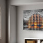 A rectangular canvas wall art print depicting a brightly lit historic building reflected in water, displayed on a light gray wall in a modern room setting next to an arched window.