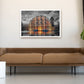 A framed art print depicting a grand illuminated palace with warm golden light reflections on water, displayed on a beige wall above a brown leather sofa in a modern living room setting.