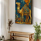 A vertical canvas wall art print featuring an ornate camel in warm gold, orange, and blue tones, displayed on a white wall above a rustic wooden bench in a styled room with plants and curtains.