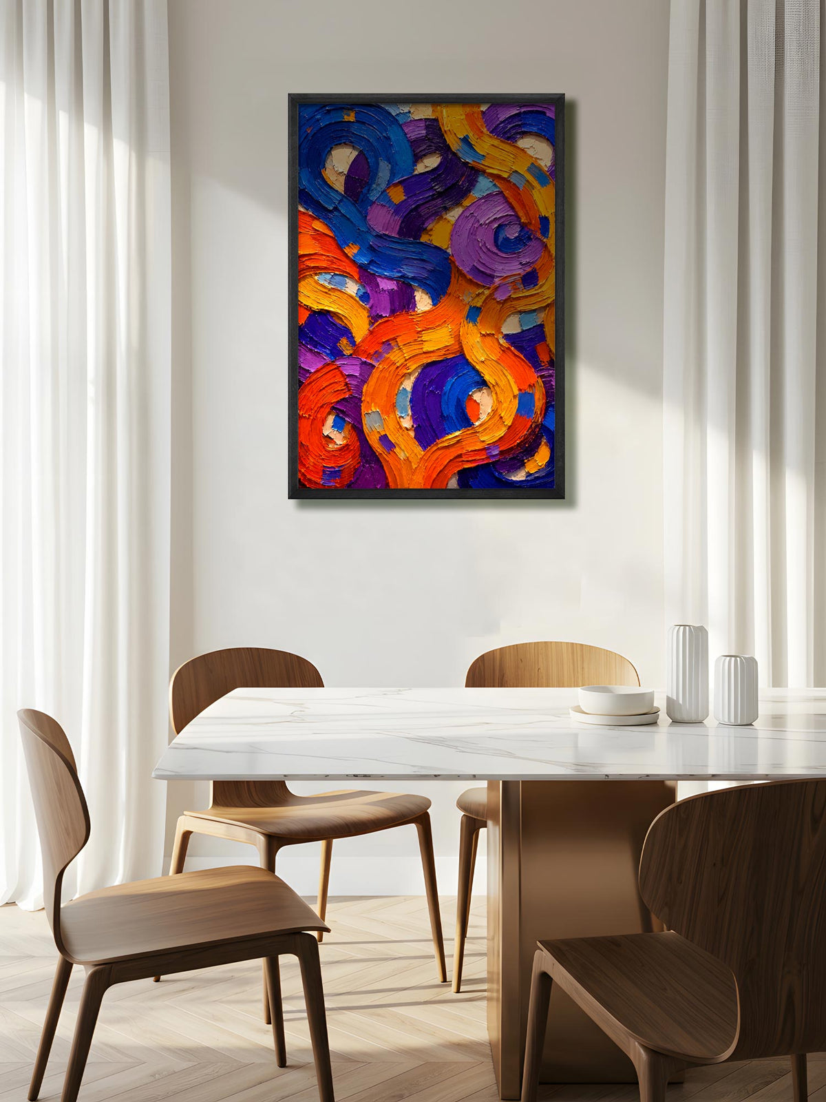 A framed abstract canvas print with swirling brushstrokes of orange, purple, blue, and yellow, hanging on a light beige wall above a dining table and chairs in a modern, sunlit room.