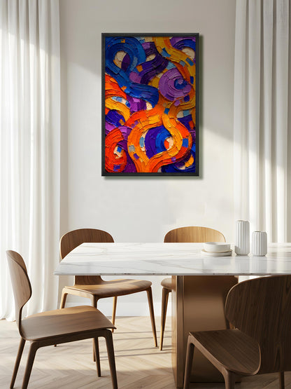 A framed abstract canvas print with swirling brushstrokes of orange, purple, blue, and yellow, hanging on a light beige wall above a dining table and chairs in a modern, sunlit room.