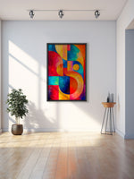 A colorful abstract geometric wall art print with bold red, blue, yellow, and orange shapes, displayed in a black frame on a white wall in a modern room with a plant and a small side table.