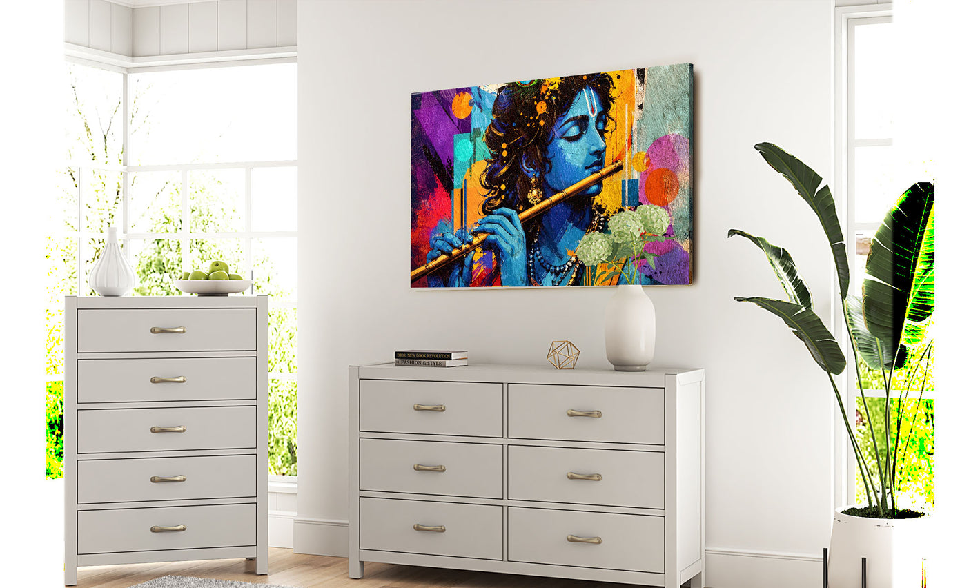 Colourful krishna abstract painting of a musical instrument on a wall above white dressers with a plant in the foreground.