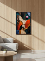 A framed abstract geometric wall art print hangs on a light wood-paneled wall in a modern living room setting with a white sofa and a round wooden coffee table.
