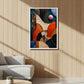 A framed abstract art print featuring geometric shapes in orange, blue, beige, and black, displayed on a light wood-paneled wall in a modern living room setting.