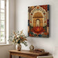 A vertical canvas wall art print depicting a traditional Indian architectural archway with a large red lotus flower, displayed in a styled room above a wooden console table with a vase of flowers and a small clock.