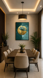 A framed wall art print featuring a stylized blue lotus flower on a teal background, displayed in a modern dining room above a dark wood table and beige chairs.