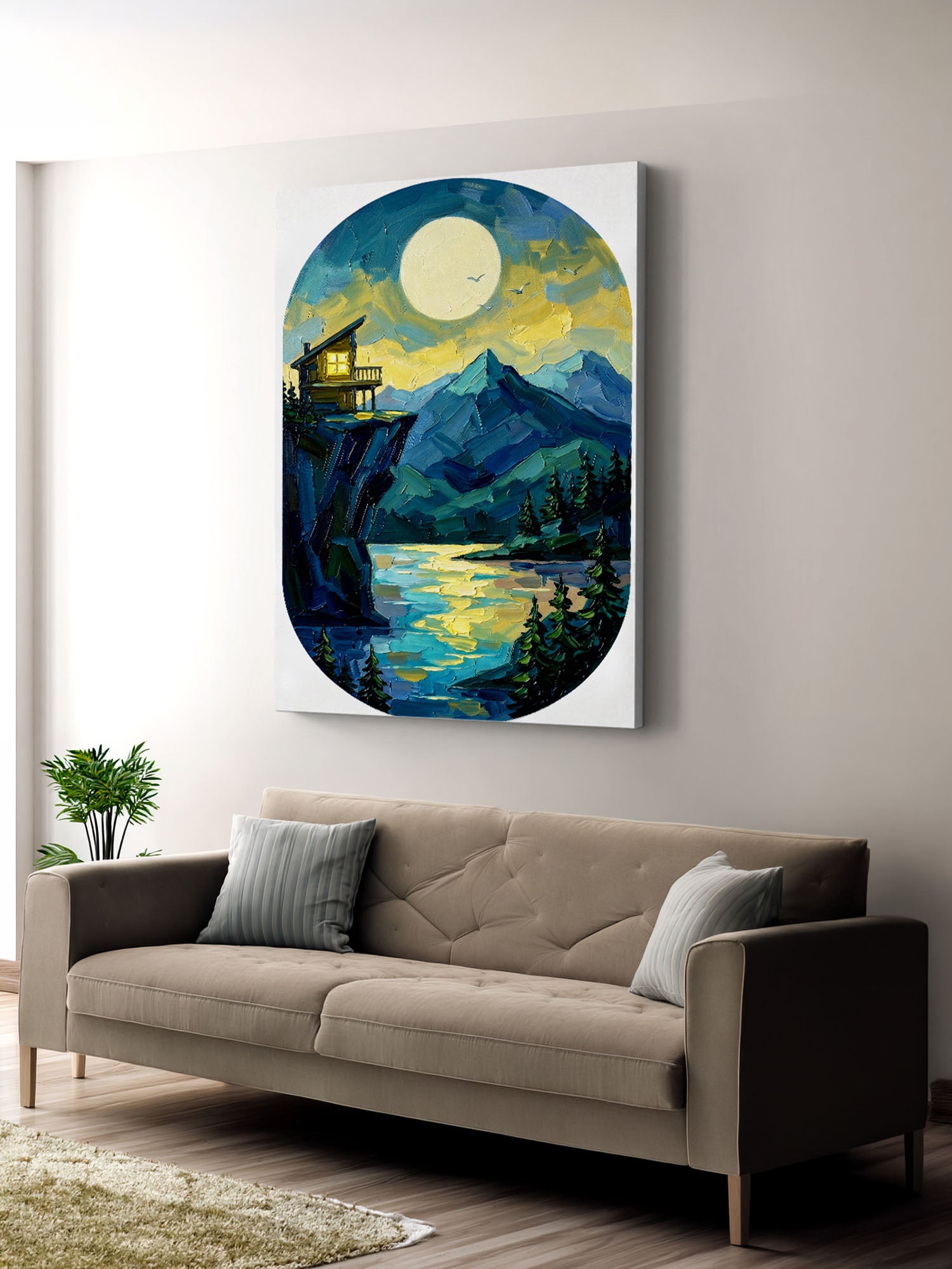 Painting of a mountain landscape with a cabin over a lake on a wall above a beige sofa.