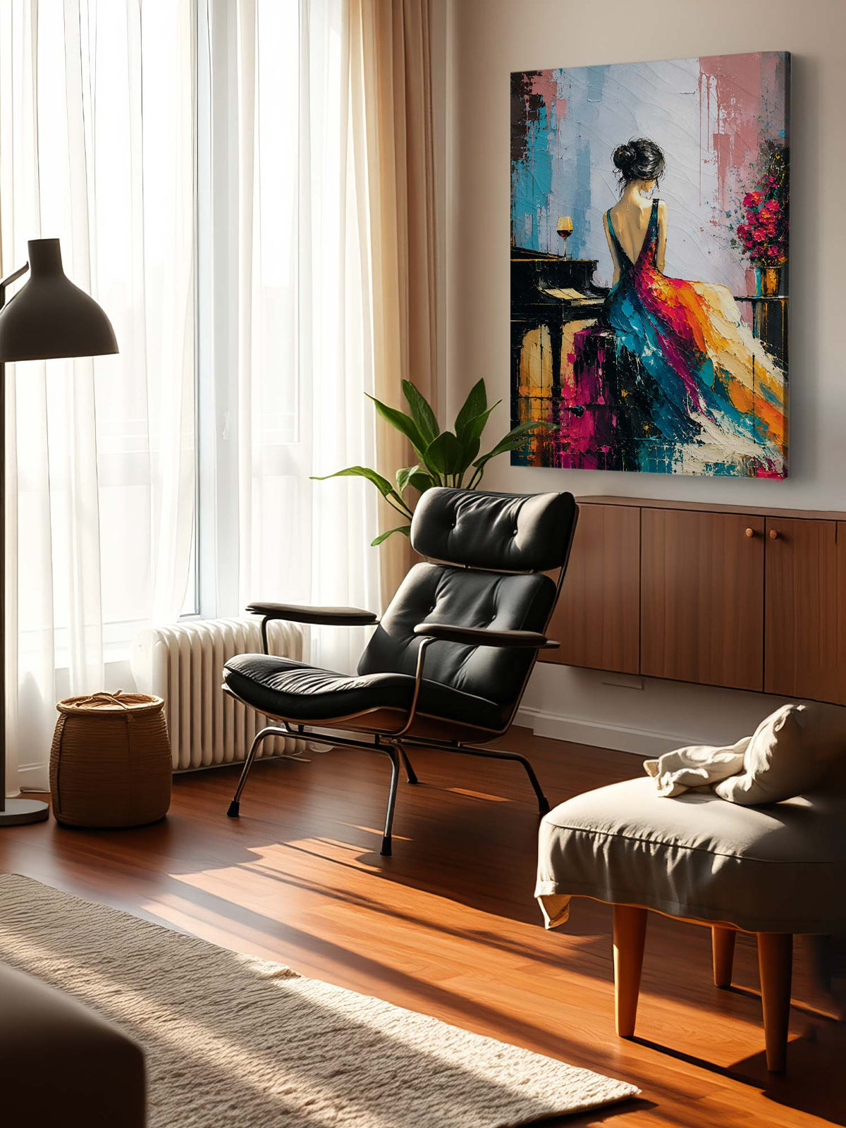 A colorful abstract canvas painting of a woman in a flowing dress hanging on a wall in a modern, sunlit living room with a black leather lounge chair and wooden floor.