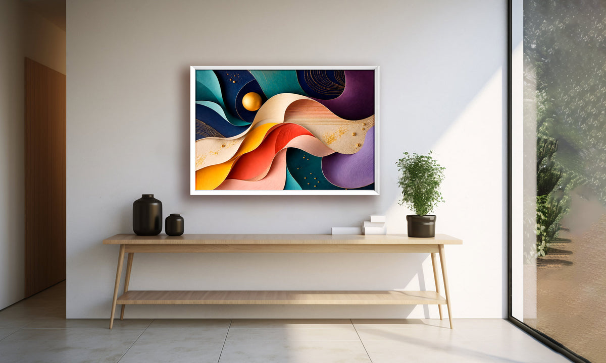 A colorful abstract wall art print with flowing curved shapes in blue, purple, orange, yellow, and red, displayed in a white frame on a light gray wall above a wooden console table in a modern interior setting.