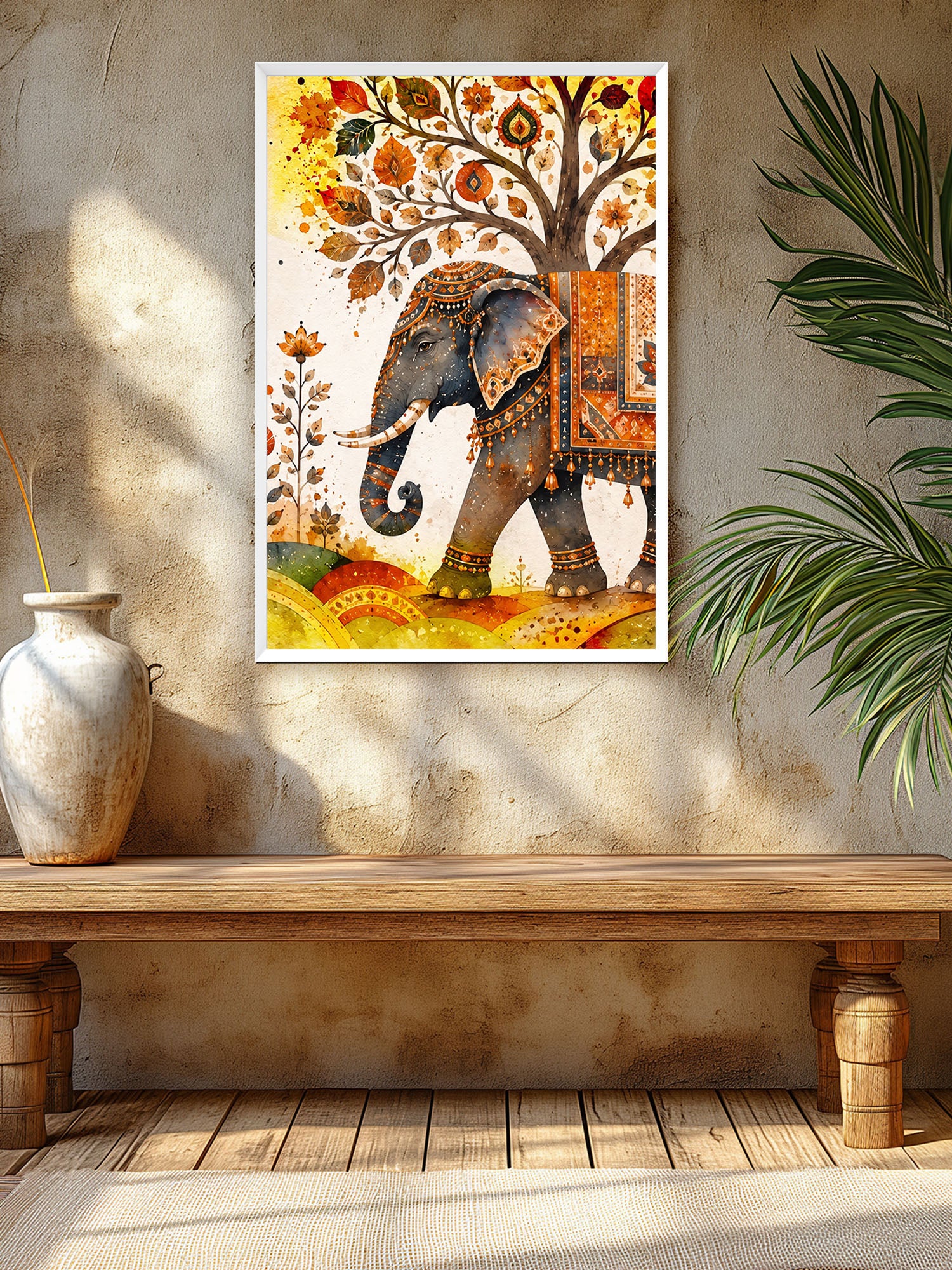 A framed wall art print featuring an ornate elephant under a tree with autumn leaves, displayed on a textured beige wall above a wooden bench, with a vase and plant nearby.