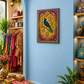 A framed colorful wall art print featuring a peacock on an ornate floral background, displayed on a light blue wall in a boutique interior with clothing racks, shelves, plants, and decorative items.
