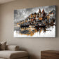 A large canvas wall art print depicting a ghat scene in Varan with boats on the river, shown hanging on a beige wall in a modern living room setting.