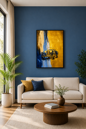A framed golden canvas wall  art print featuring a vintage car, displayed a dark blue wall in a modern living room setting with a cream sofa, wooden coffee table, and potted plants.